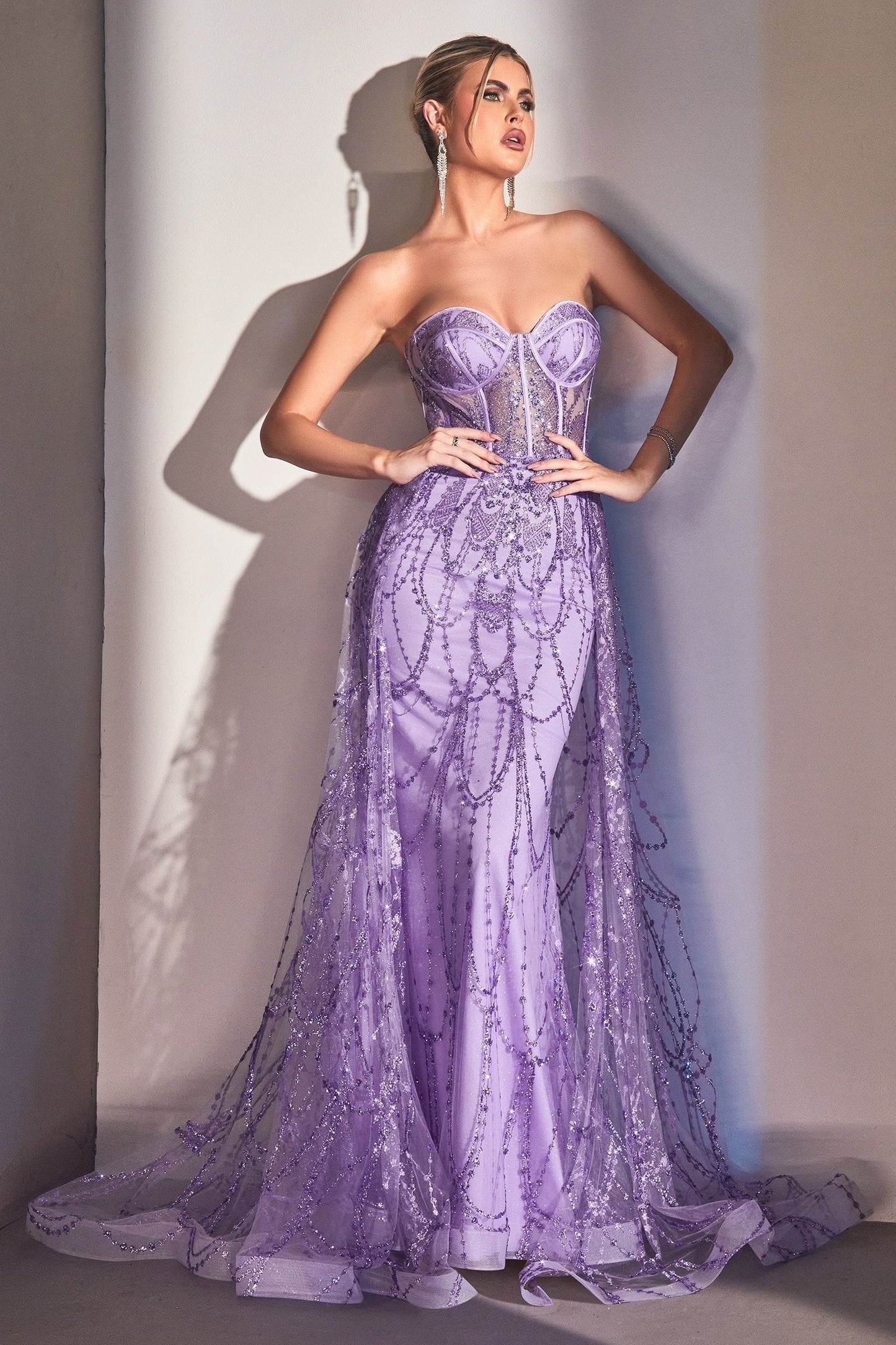 Romantic and feminine strapless mermaid gown with a sheer overskirt in lavender color