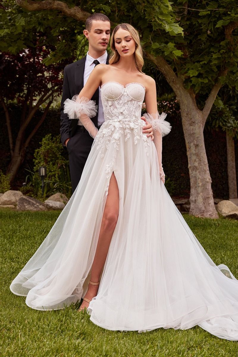 Graceful tulle wedding dress featuring a sheer boned structure, pleated tulle design, and removable ruffled tulle gloves for an extra touch of romance